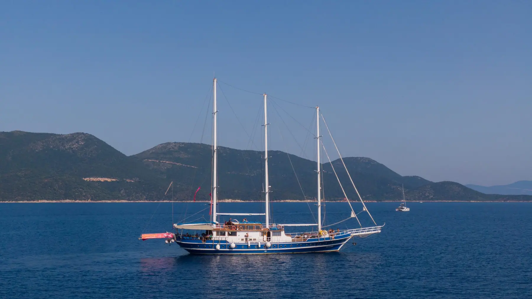 Gulet vor Anker vor einer bewaldeten Insel in der Ägäis
